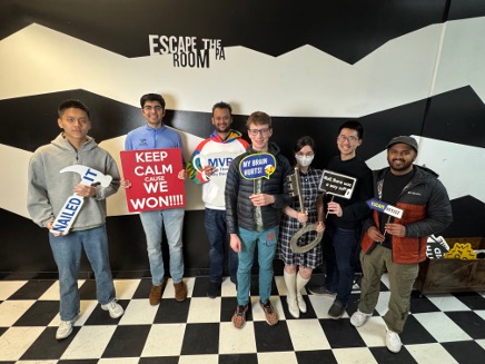 SPUD Lab members posing with novelty signs after an escape room outing
